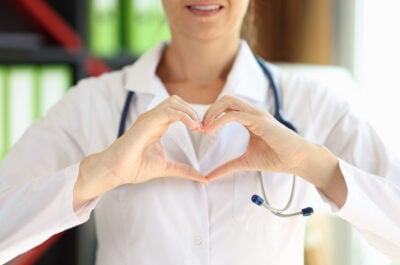 Smiling female doctor making a heart gesture for Doctors Day