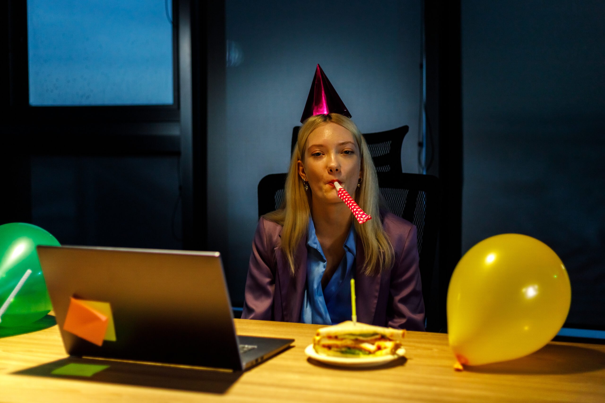 Woman on birthday sitting alone in front of computer