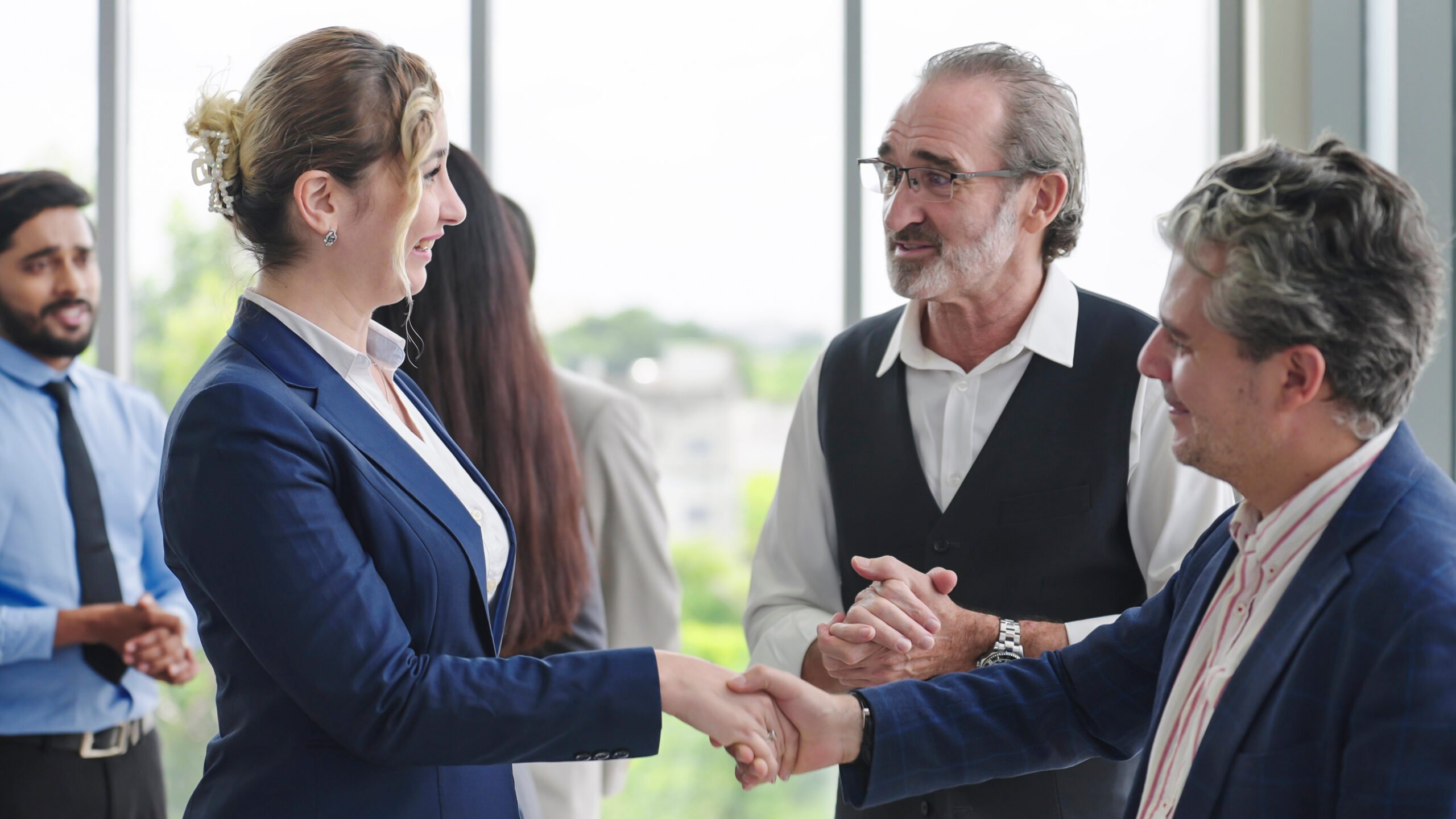 Two senior leaders welcoming a new employee to the team