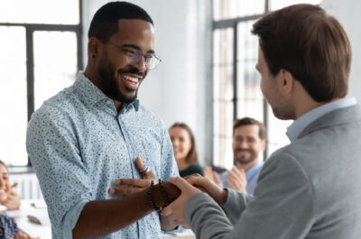 employee receiving congratulations for his promotion in workplace