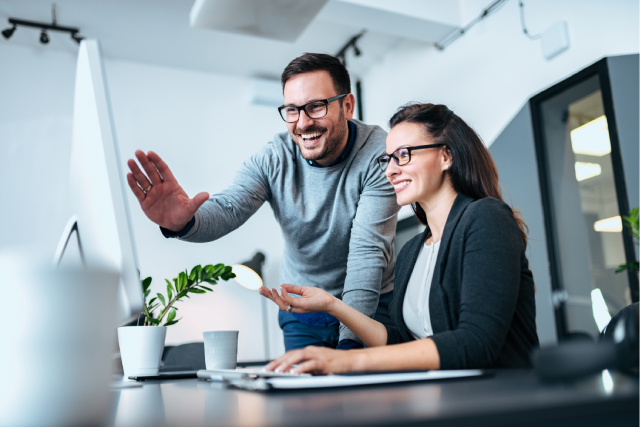 Two employees talking about what is a group eCard on a computer