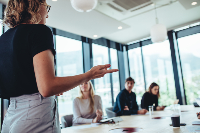 Person explaining how to roll out an employee recognition program to boardroom