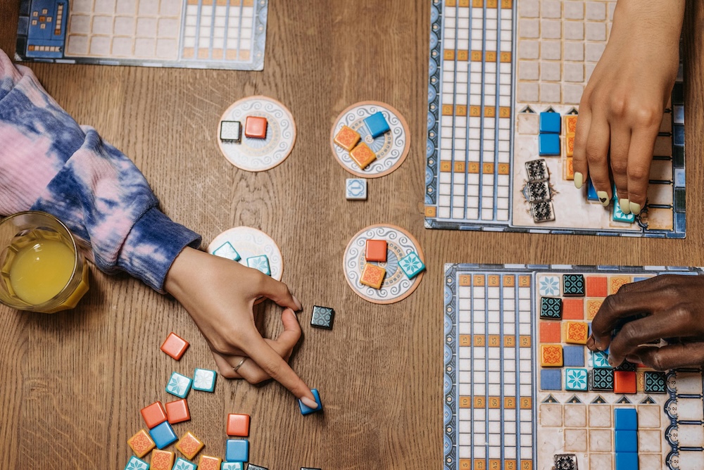 Hands over game pieces at a virtual retirement party