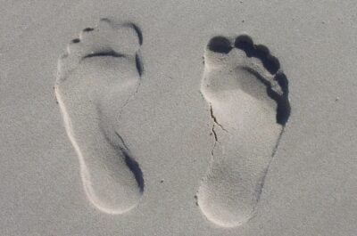 Footprints shown clearly in sand, demonstrating the carbon footprint of ecards