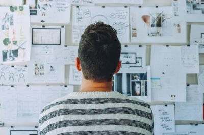 Man sitting in front of a mind map on a bulletin board