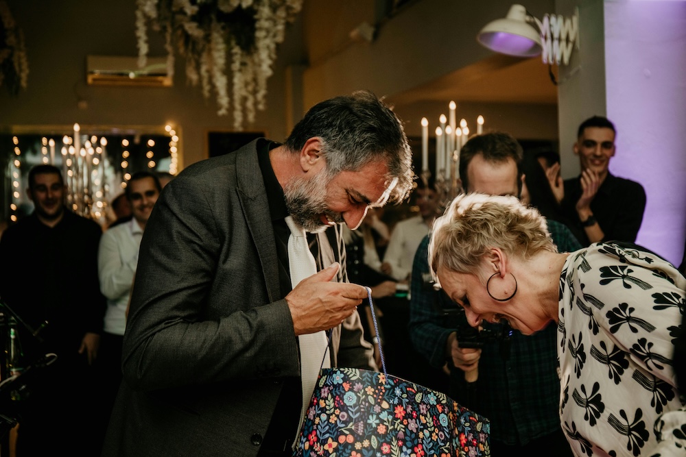 Two people looking in a gift bag at a virtual retirement party