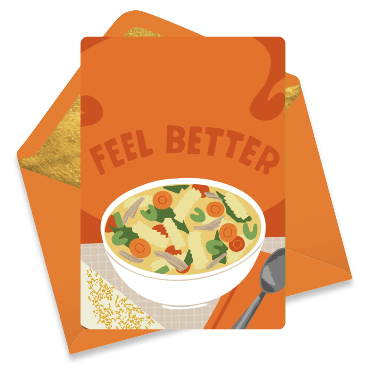 A warm get well card featuring a bowl of steaming soup with vegetables on an orange plaid tablecloth background and an orange envelope.