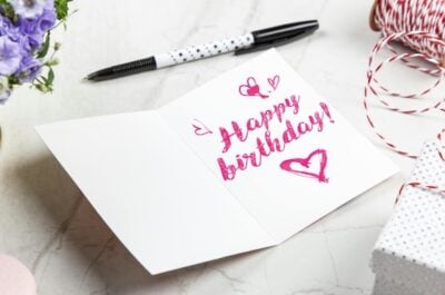 A Happy Birthday message written inside a card, with a pen laid nearby.