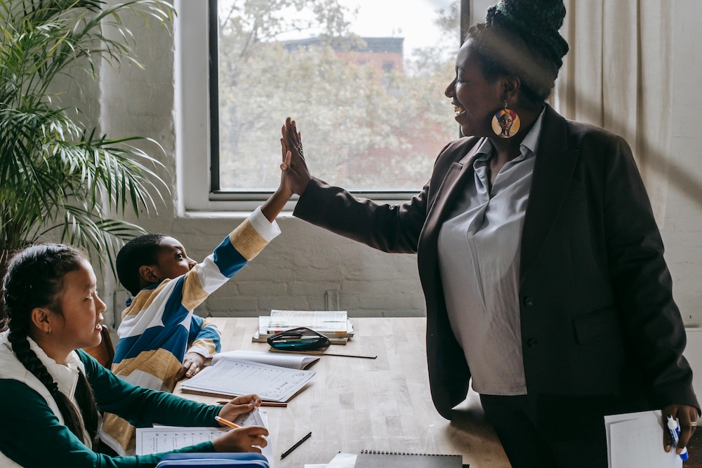 A student high fives a teacher for their birthday.