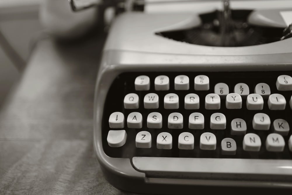 A black and white photo of a broken vintage typewriter with several keys depressed perfect for typing birthday wishes to your nephew.
