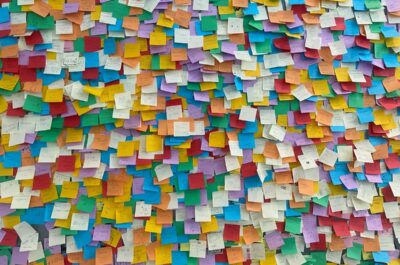 Wall covered in multicolored Post-its, evoking an eCard-style board for employee recognition, staff recognition, and healthcare employee appreciation.
