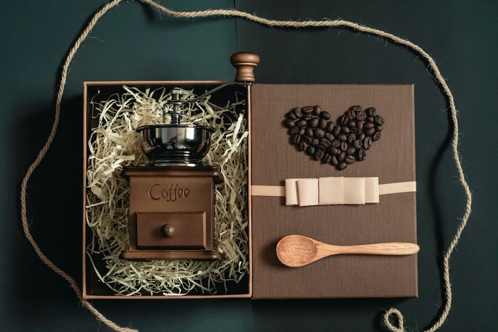 A coffee gift box with a grinder and beans makes the perfect holiday gift for employees