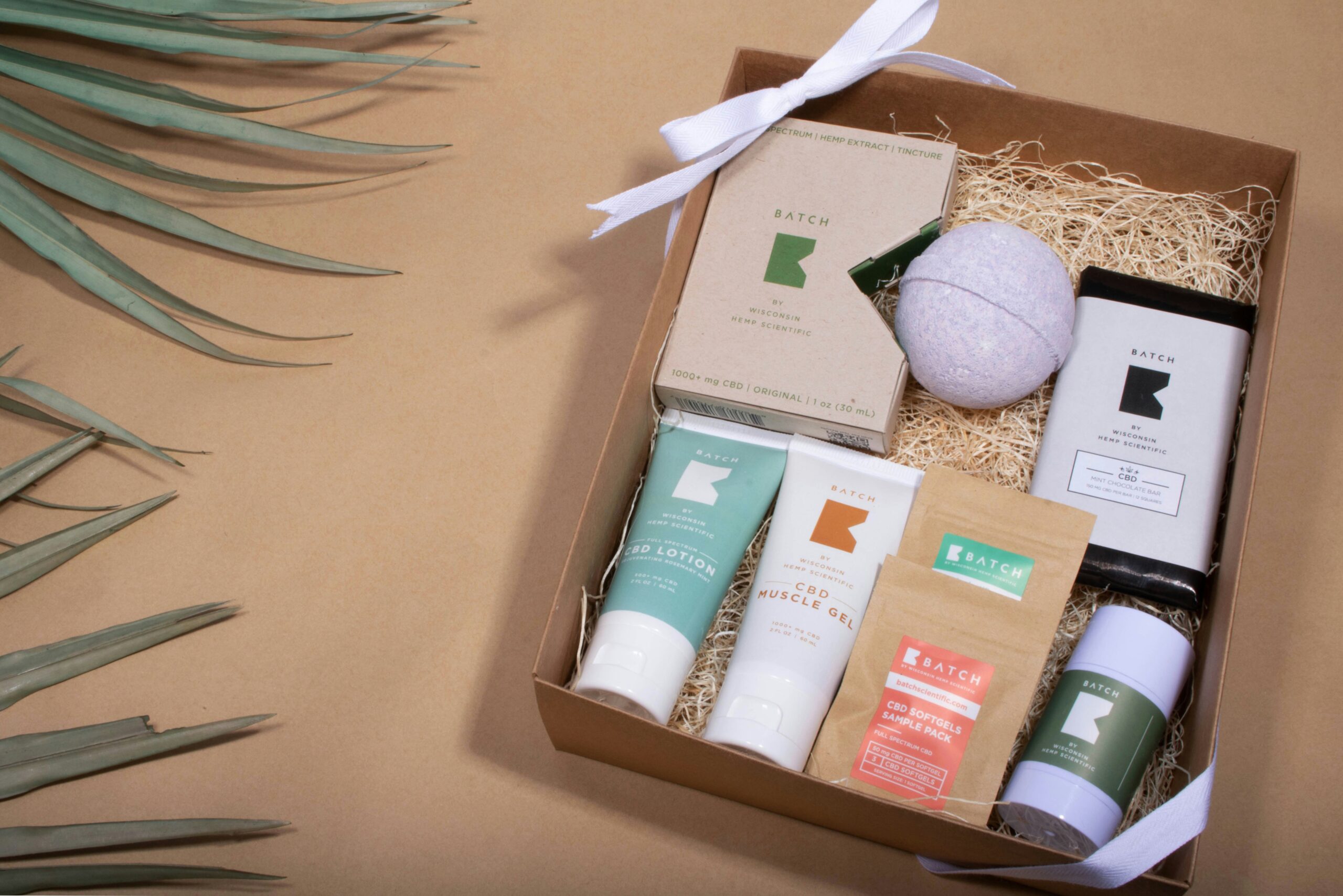 A carefully curated bath-themed holiday gift box from Batch, with a bath bomb, lotions, soaps, and other products in a box, with a white ribbon tied at the corners.