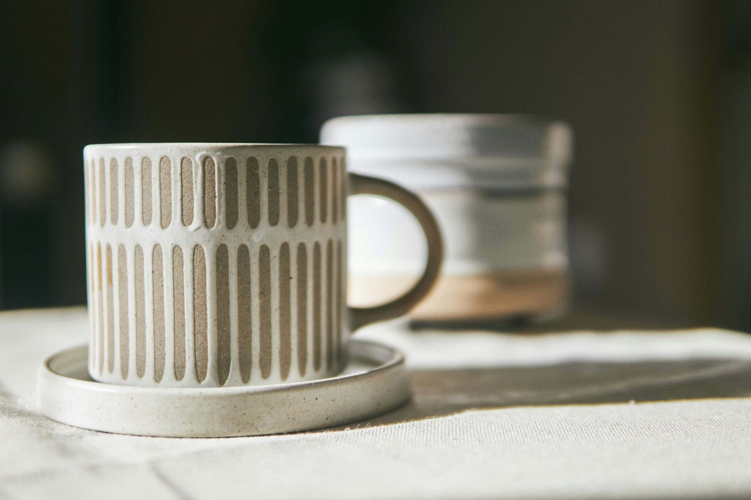 An elegant neutral ceramic and white mug holiday gift, displayed in a mug warmer