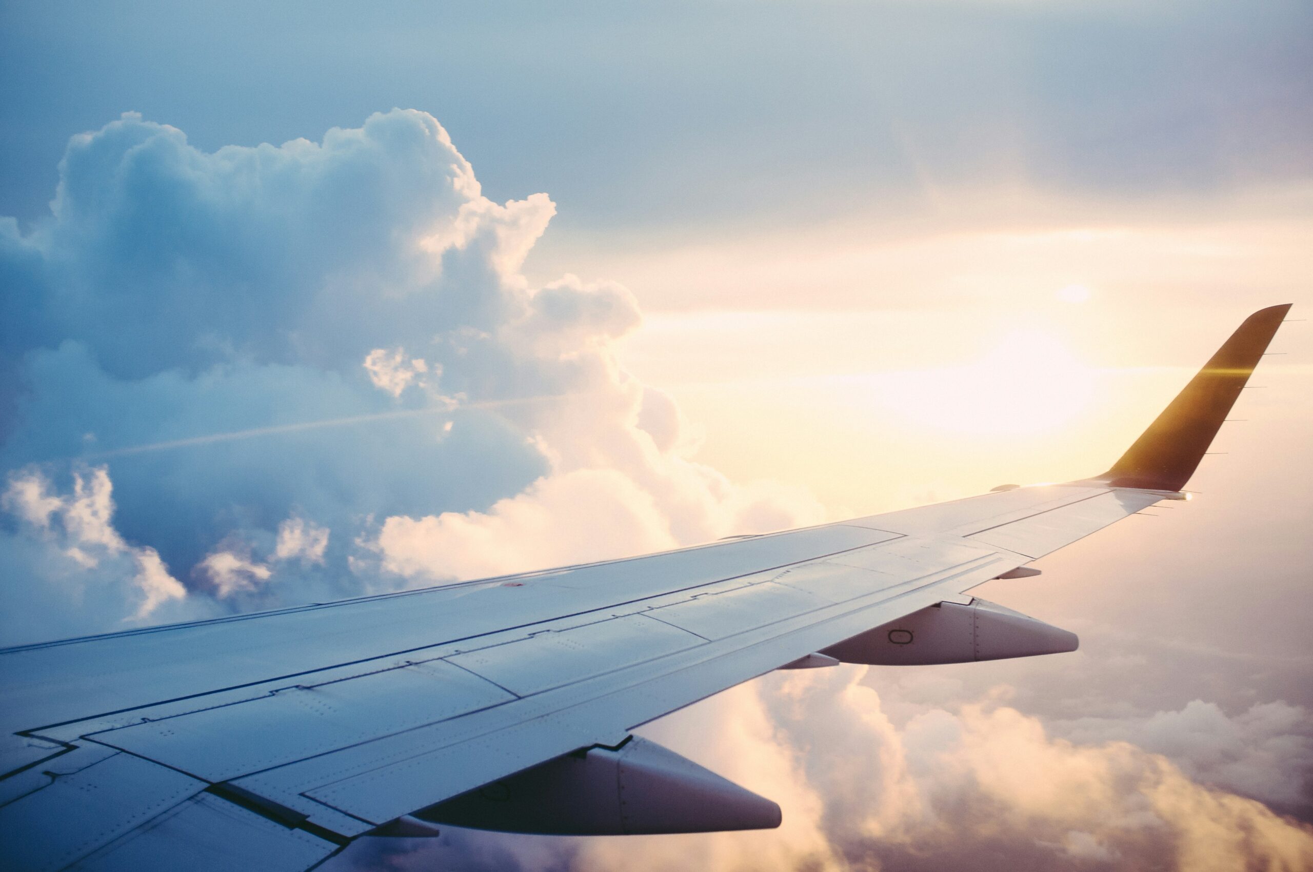 A bright horizon showing clouds and the wing of an airplane, trip given as a holiday gift