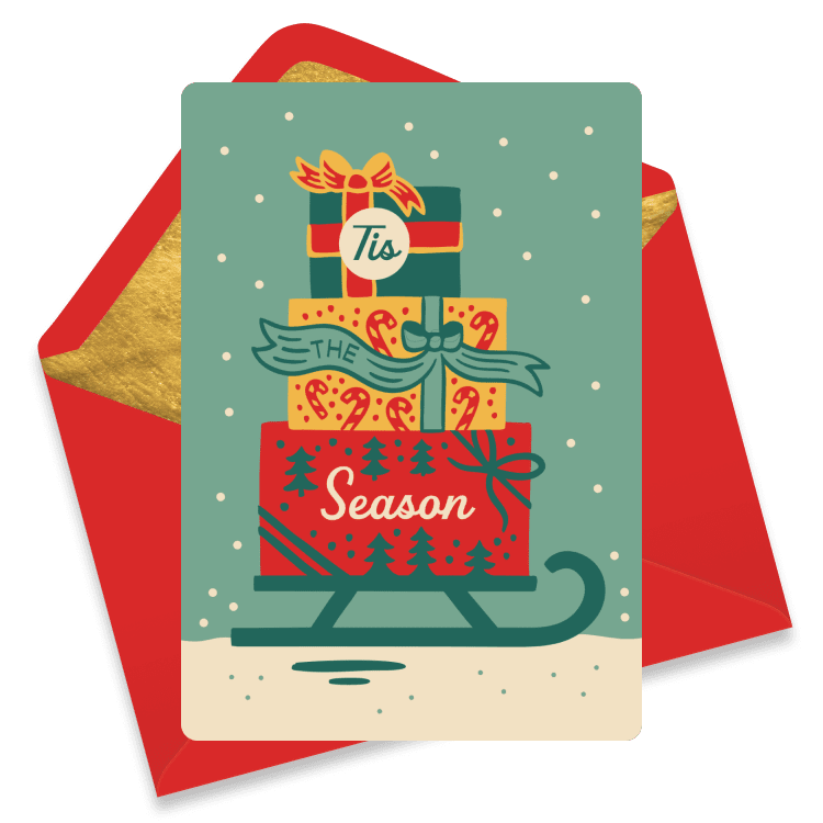 A Christmas card with stacked presents on a sled reading 'Tis the Season'.